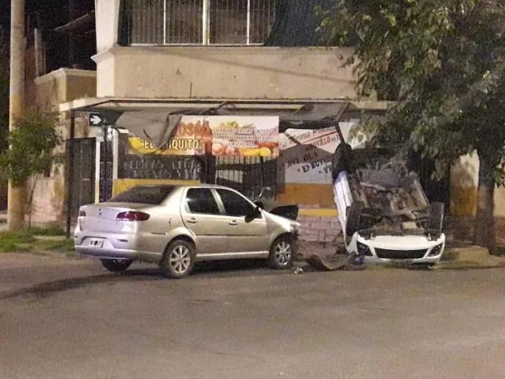 Fuerte choque entre dos autos: uno quedó dado vuelta en la vereda de un comercio