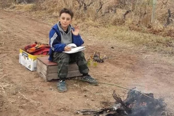 Cumple sus tareas virtuales junto a su padre en medio de la finca y al lado de una fogata