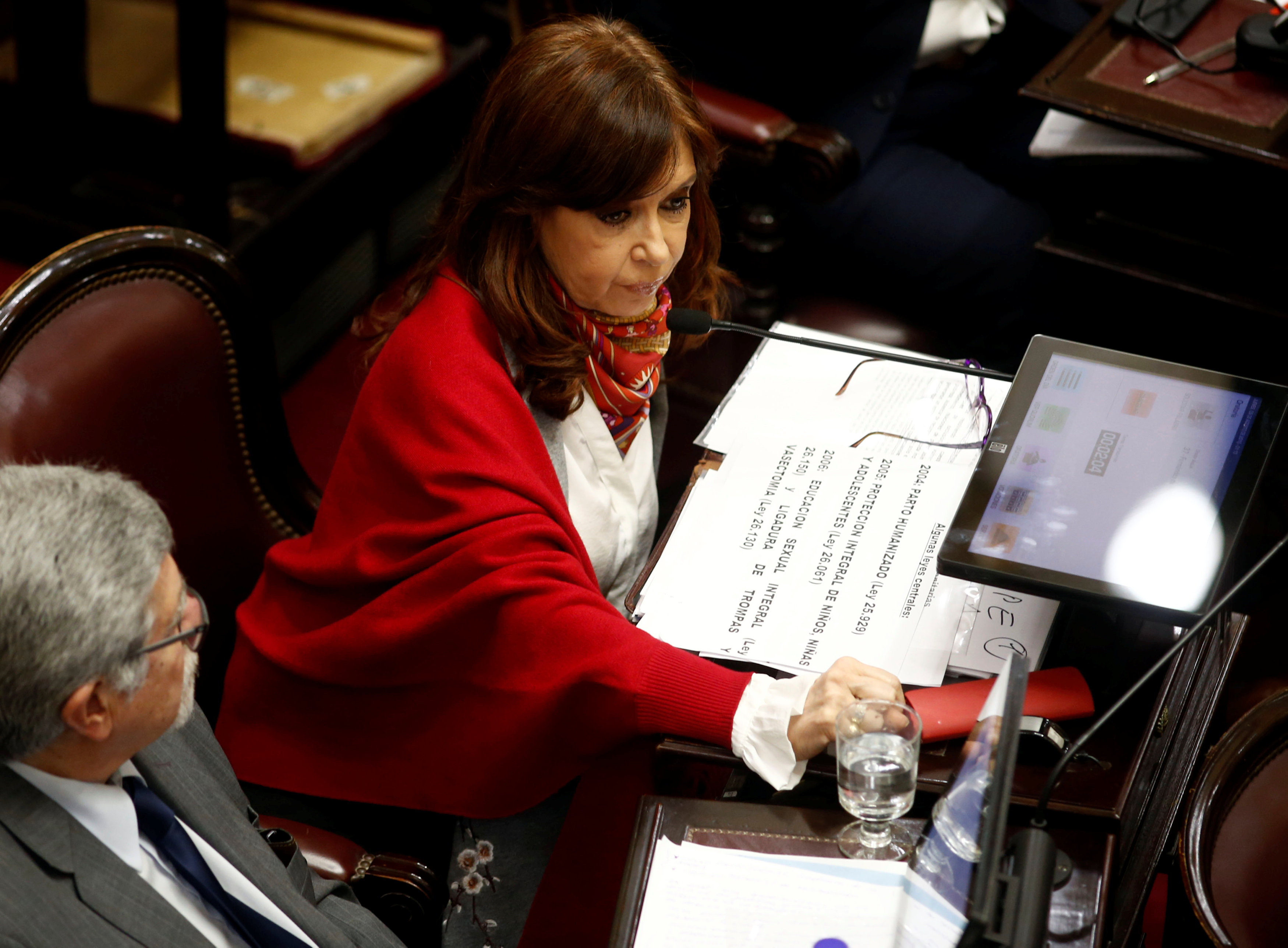 Senator and former Argentine President Cristina Fernandez de Kirchner sits next to Senator Marcelo Fuentes as lawmakers debate on a bill that would legalize abortion, in Buenos Aires